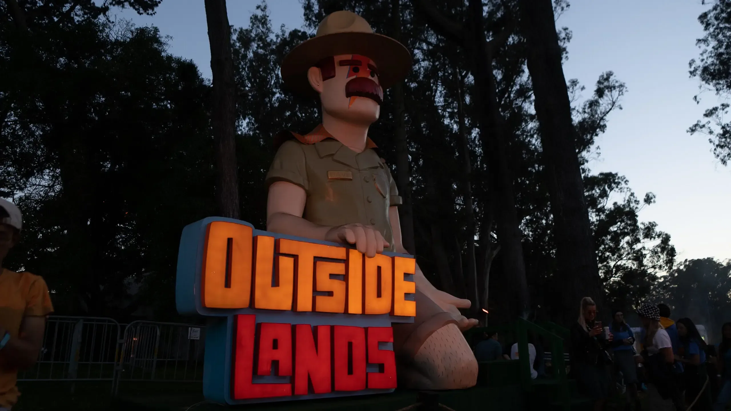 A large statue of a man wearing a hat and shorts with the words "Outside